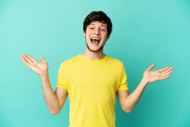 Young Russian man isolated on blue background with shocked facial expression - Photo, Image