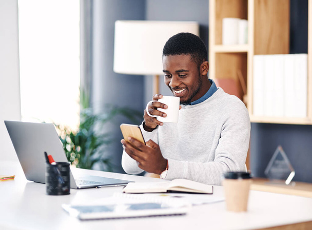 Чорний чоловік, посмішка та ноутбук в офісі зі смартфоном для веб-дизайну, онлайн-проекту та соціальних медіа. Ділова людина, корпоративна та щаслива робота над цифровими технологіями для досліджень, планування та веб-сайту. - Фото, зображення
