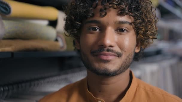 Arabský indický latino muž kupující zákazník nakupování koupit oblečení textilní materiál v textilním obchodě šťastný radostný úsměv muž prodavač módní návrhář stylista krejčí při pohledu na kameru úsměv práce v ateliéru - Záběry, video