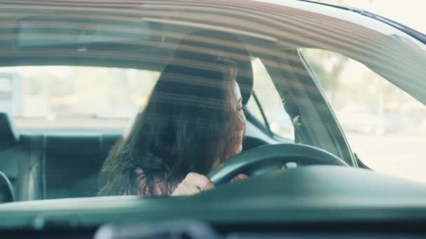 Kapısı açık bir kadın, arabada oturuyor, emniyet kemerini takıyor. Şoför sürmeye hazır. Yavaş çekim videosu - Video, Çekim