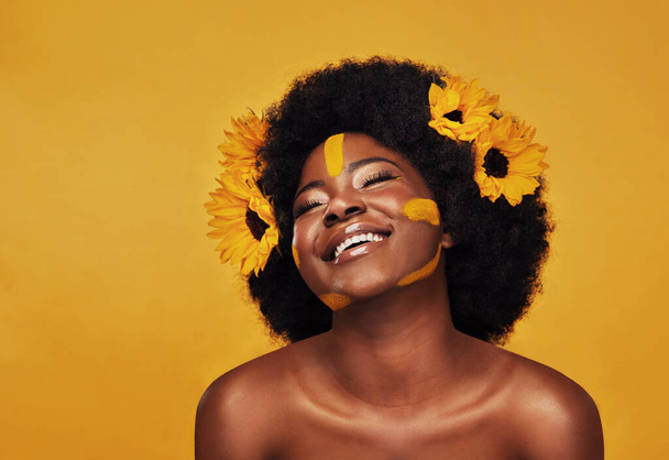 Czarna kobieta, studio i naturalne słoneczniki na wiosnę, naturalne pielęgnacji skóry i odpoczynku z afrykańskiego modelu i afro. Samopielęgnacja, wellness dla piękna z kosmetykami organicznymi, dermatologia na żółtym tle. - Zdjęcie, obraz