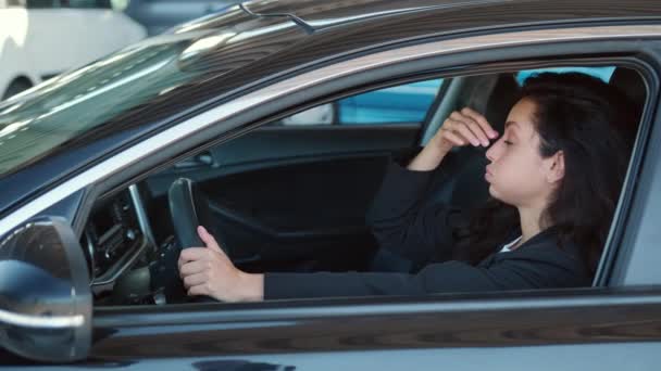 Portret van een vrouw in de auto met open raam, drukt vermoeidheid en verdriet emoties. Video in slow motion - Video