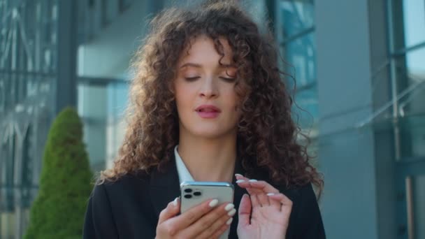 Кавказька жінка дівчина бізнес-леді використовує смартфон у місті жінка-підприємець думає, що мрія роздумує створити ідею посмішки, набравши відповідь на мобільний чат онлайн на відкритому повітрі - Кадри, відео