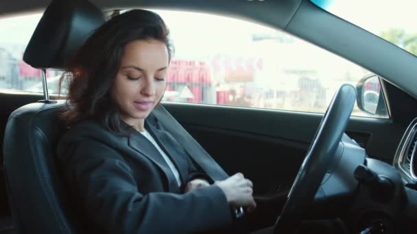 El retrato de la mujer sentada en el coche, se pone el cinturón de seguridad. Conductor listo para conducir. Vídeo en cámara lenta - Imágenes, Vídeo