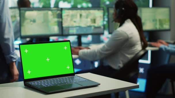 A laptop running isolated mockup display in a monitoring room, people working with surveillance footage from CCTV security cameras around the city. Greenscreen in a government agency. Camera A. - Footage, Video