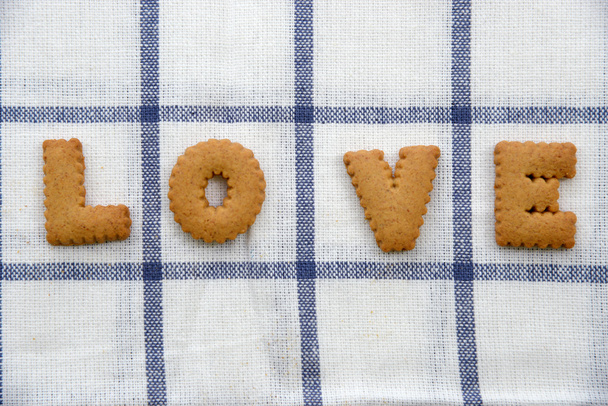 Biscuits form in word "love" on tablecloth. - Фото, изображение