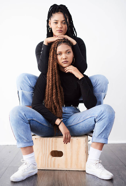 Lesbian couple, portrait and fashion in studio with confidence for style inspiration, white sneakers and love. Serious, lgbt and black people together for support, relationship and braids with jeans. - Photo, Image