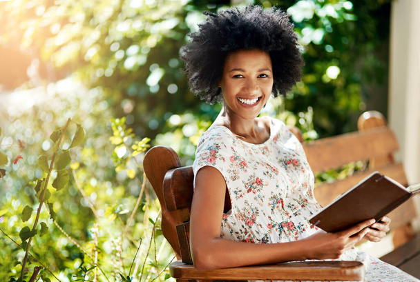 Femme africaine, heureuse et réserver sur banc de parc en portrait pour se détendre en vacances avec l'histoire, la langue et l'apprentissage. Fille, personne et sourire avec roman, littérature et vacances avec soleil à Atlanta. - Photo, image