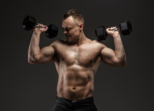 Awesome muscular guy with dumbell - Фото, зображення