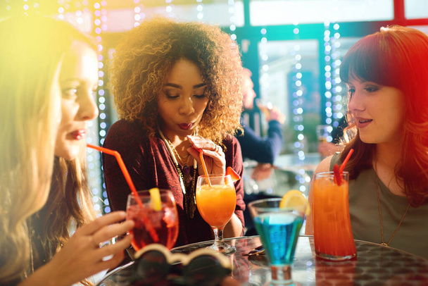 Feest, vrienden en cocktail drinken in de pub samen voor feest, evenement of happy hour in de nachtclub. Groep, meisjes en vrouwen met alcoholglas aan de bar voor sociale bijeenkomst, rave of bokeh met fakkel. - Foto, afbeelding