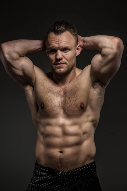 muskulöser Mann posiert im Studio auf grauem Hintergrund - Foto, Bild
