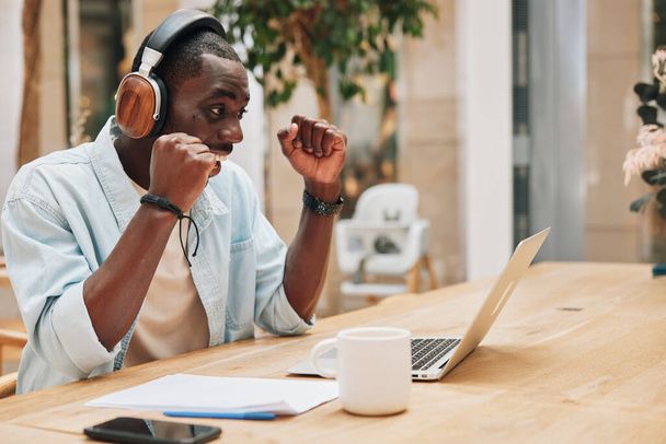 Man desk hallgatni alkalmazott fülhallgató dolgozó üzleti üzletember férfi online munka laptop fekete zene kommunikáció headset számítógép fiatal fejhallgató technológia személy munkahelyi szakmai iroda - Fotó, kép