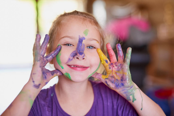 Happy, girl and paint on hands in portrait with fun for creative learning, education and growth with messy art. Smile, child and fingers as painter for childhood, sensory and fine motor skills. - Photo, Image
