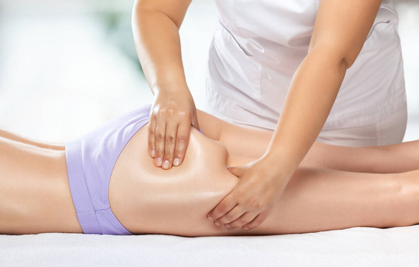 Massaggiatore fa massaggio anticellulite su gambe, cosce, fianchi e glutei nella spa. Trattamento sovrappeso, body sculpting.Cosmetologia e concetto di massaggio. - Foto, immagini