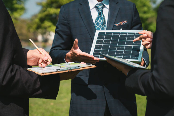 Zewnętrzne spotkanie biznesowe na temat energii słonecznej, grupy biznesmenów pracujących i burzy mózgów na temat wykorzystania alternatywnych technologii energetycznych jako korporacyjnego zaangażowania w działania CSR. Żywica - Zdjęcie, obraz