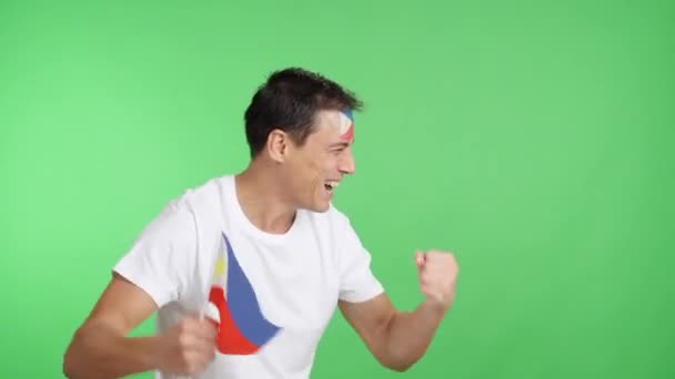 Videó a stúdióban egy férfi kromájával, aki a Fülöp-szigeteknek szurkol, sikoltozik és nemzeti zászlót lengetve, üres kézzel néz félre a másolótérre. - Felvétel, videó