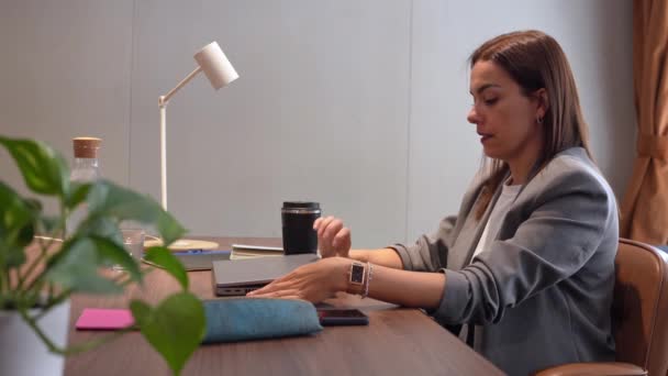 mujer que trabaja en una oficina escribiendo en el portátil - Imágenes, Vídeo
