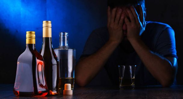 Flaschen mit alkoholischen Getränken und die Figur eines Betrunkenen - Foto, Bild