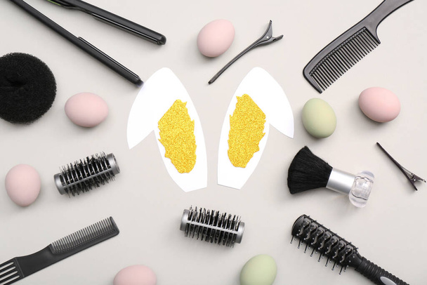 Orecchie di coniglio di carta con uova di Pasqua e accessori per parrucchieri su sfondo bianco - Foto, immagini