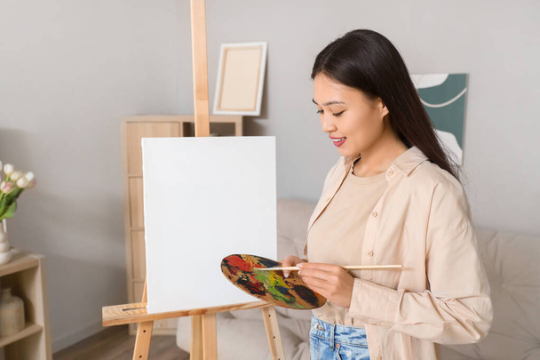 Female Asian artist with paint palette at home - Photo, Image
