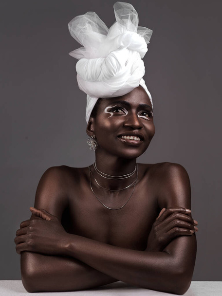 Denken, wickeln oder schwarze Frau mit Make-up, Stolz oder Schönheit im Studio auf grauem Hintergrund. Hautpflege, Mode oder Happy African Model mit traditionellem Turban, Lidschatten-Kosmetik oder Halskette für die Kultur. - Foto, Bild