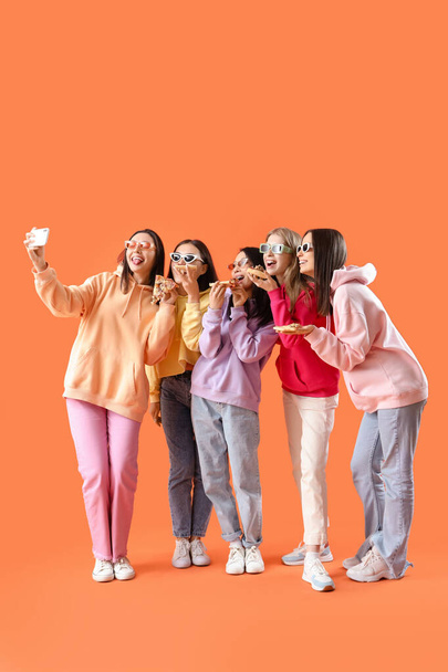 Jonge vrouwen met pizza selfie op oranje achtergrond. Kippenpartij - Foto, afbeelding