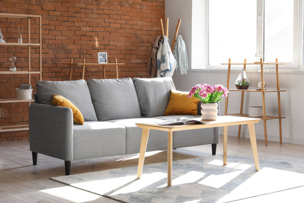 Interiér stylového obývacího pokoje s pohovkou a tulipány na stole - Fotografie, Obrázek