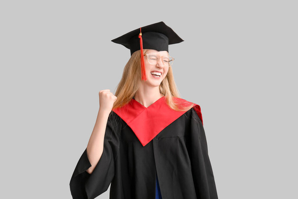 Счастливая выпускница в миномётной доске на сером фоне - Фото, изображение