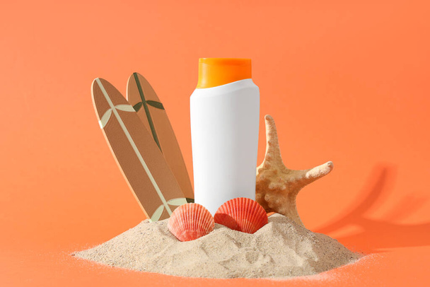 Композиція з купою піску, сонцезахисним кремом і декором на кольоровому фоні - Фото, зображення