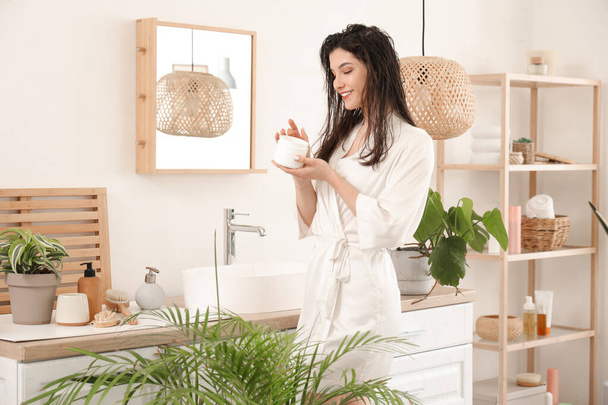 Bella giovane donna felice con vaso di maschera per capelli in bagno a casa - Foto, immagini