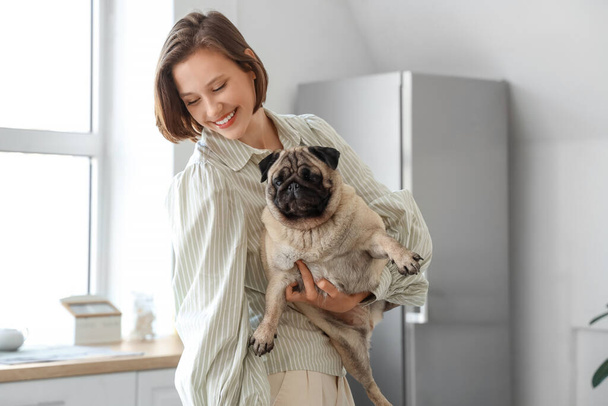 Mladá žena drží roztomilý pug dog doma - Fotografie, Obrázek