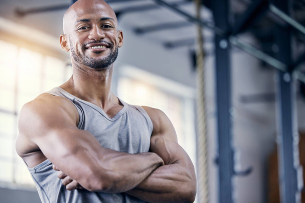 Man, portrait and arms crossed in gym for exercise with smile, training or workout for fitness. Male person, confident or personal trainer in sports club or strong, cardio or wellness in Chicago. - Photo, Image