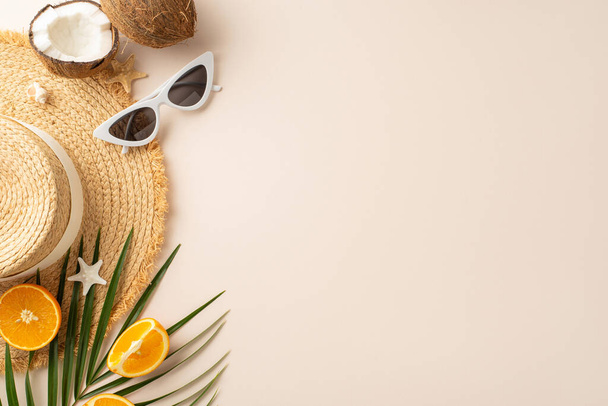 Paraíso de verano capturado: vista superior de sombrero de paja, gafas de sol, frutas exóticas suculentas naranjas, cocos, hojas de palma, conchas y estrellas de mar en un escritorio beige pastel - Foto, Imagen