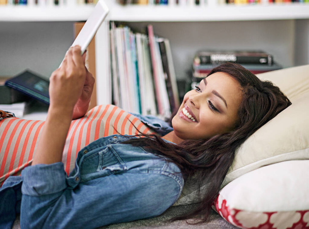 Black woman, relax and happy on bed with tablet for online entertainment, social media or streaming trending videos. Person, digital technology and internet for connectivity and scroll on website - Photo, Image