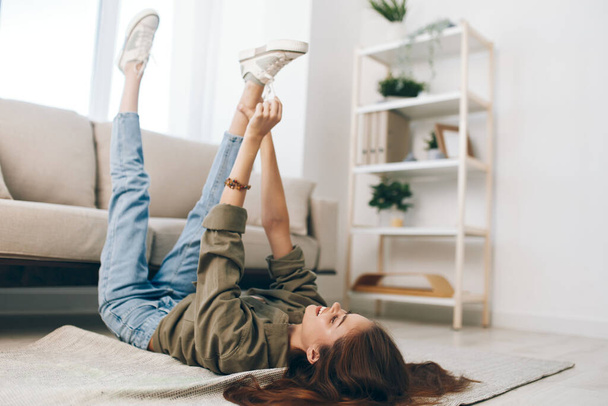 Happy Woman se détendre sur un canapé confortable dans un appartement moderne - Photo, image