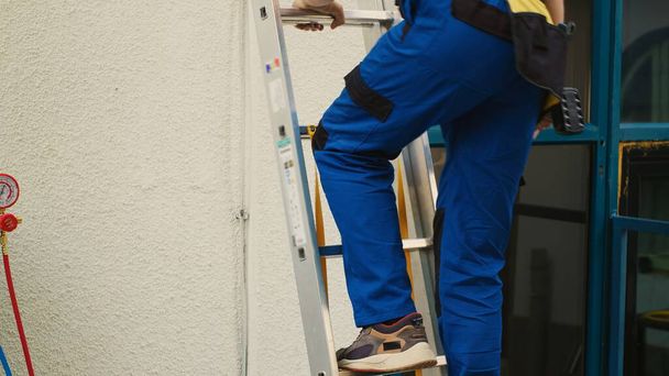 Asiantuntija korjaaja ammatillinen yhtenäinen tekniset laitteet kiipeily taitto tikkaat tehdä huolto katolla ilmastointilaite. Tehokas teknikko tilattu tarkastamaan hvac-järjestelmä - Valokuva, kuva