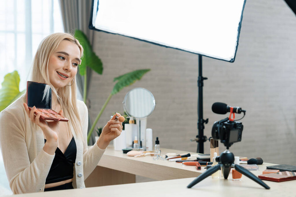 Молода жінка робить косметичний відео-контент для соціальних медіа. Блогер краси посміхається фотоапарату, показуючи, як доглядати за аудиторією або послідовниками. Блайт - Фото, зображення