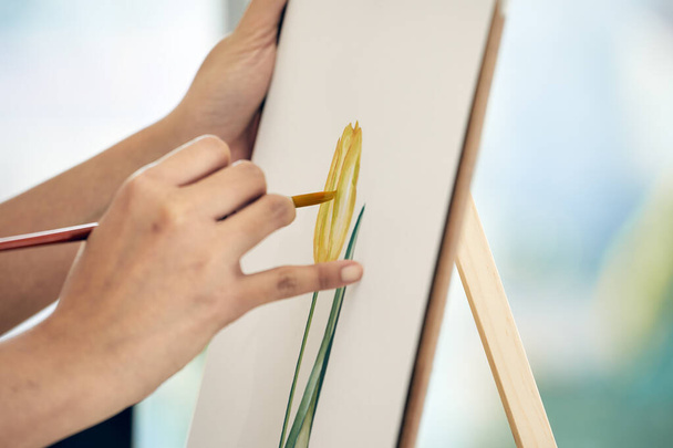 Close-up tiro de mão delicadamente pintar flor tulipa amarela em papel de lona, destacando detalhes e precisão na criação de arte - Foto, Imagem