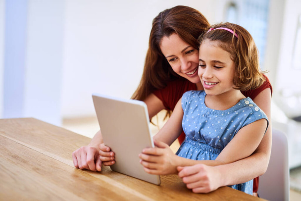 Μητέρα, κορίτσι και tablet για μάθηση στο σπίτι, online παιχνίδι και απομακρυσμένη τάξη ή εκπαίδευση στο τραπέζι. Κόρη, μαμά και streaming κινούμενα σχέδια ή παιχνίδια για την ανάπτυξη του παιδιού, συγκόλληση και υποστήριξη στην παιδική ηλικία. - Φωτογραφία, εικόνα