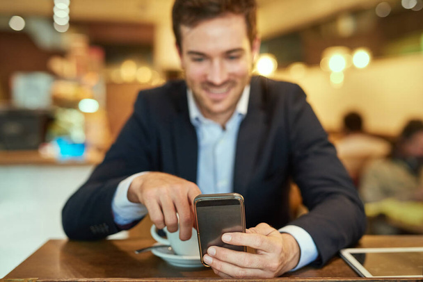 Uomo d'affari, smartphone e caffè per rilassarsi nel caffè per la ricerca online, navigare in internet o leggere la comunicazione. Persona, tazza e tecnologia mobile nel negozio per scorrere, pubblicare o aggiornare i social media. - Foto, immagini