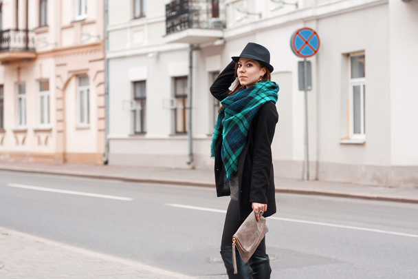 Porträt einer schönen Frau mit Schal und Hut am Straßenrand. - Foto, Bild