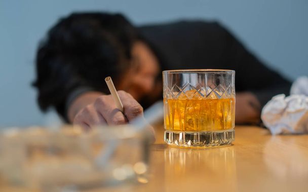 Zastřelen selhávajícím podnikatelem, vážný a pít whisky a kouřit za stolem v kanceláři. Selektivní zaměření na předmět. - Fotografie, Obrázek
