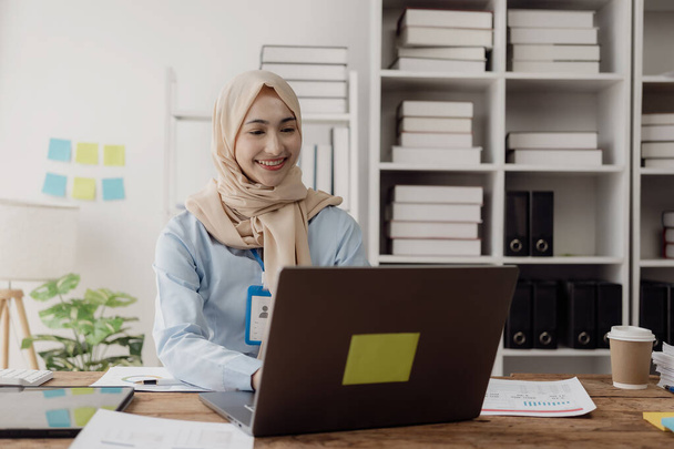 Muszlim közgazdász nő online dolgozik számviteli dokumentumok modern laptop eszköz, írás, jegyzetel számítások, csinál pénzügyi, matematika adóhivatal asztalon. Számvitel - Fotó, kép