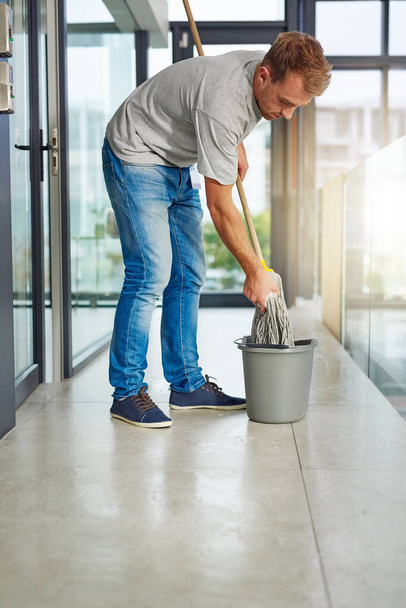 Janitor, mop or cleaning floor in office for housekeeping, building maintenance and hygiene services. Bucket, hospitality professional or caretaker in workplace for health, maintenance or bacteria. - Photo, Image
