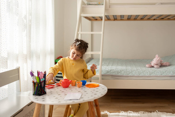 Petite fille jouer avec jouet en plastique cuisine à l'intérieur à la maison.  - Photo, image