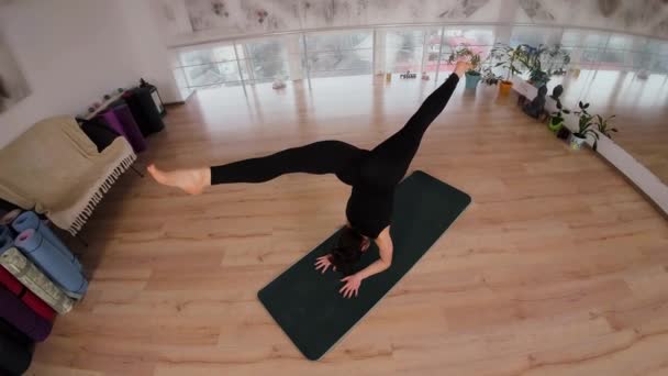 Jonge vrouw doet meditatie oefening voor flexibiliteit en stretching sport yoga, kleding zwarte sportkleding. Vrouwelijke praktiserende yoga concept natuurlijke balans tussen lichaam en mentale ontwikkeling - Video