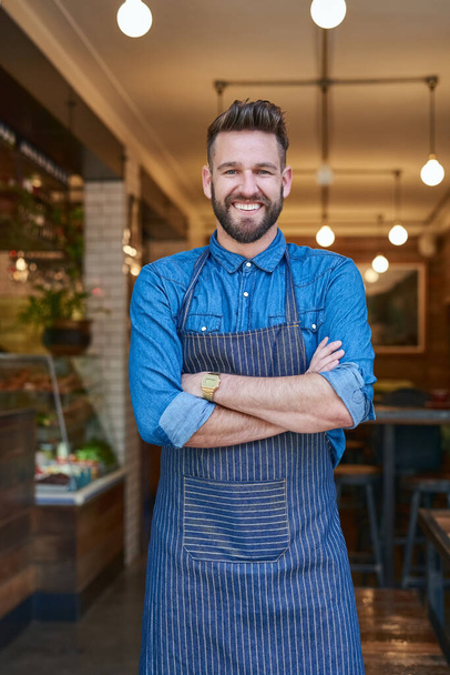 Portret, barista en geluk in cafe voor startup bedrijf, restaurant en trots voor het werk. Man, kleine ondernemer en glimlach voor voeding, welzijn en gezondheid in coffeeshop in New York. - Foto, afbeelding