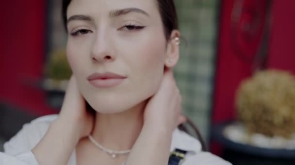 A high-definition close-up depicts a young womans calm face, focusing on her subtle smile and detailed facial features. Close-Up Portrait of Young Woman With a Neutral Expression - Footage, Video