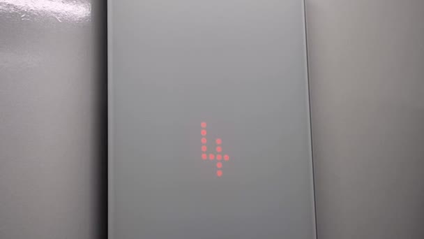 El interior del ascensor con un panel de cristal. El indicador de suelo se ilumina con un número rojo y el movimiento hacia abajo. Primer plano - Metraje, vídeo