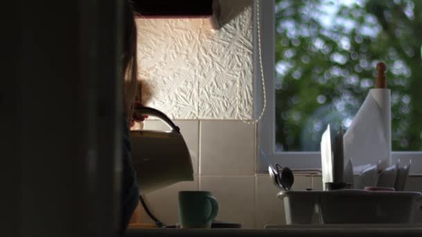 Frau gießt Heißgetränk aus Wasserkocher in Küche Medium-Zoom-Aufnahme Zeitlupe selektiver Fokus - Filmmaterial, Video